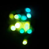 glowing blob of green and blue coloured light bokeh