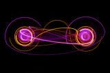 lightpainting of two circular shapes with interconnected ribbons of light
