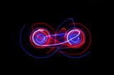 lightpainting background featuring two interlinked circles of light with vibrant red and blue streaks
