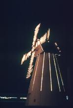 motion blurred night time picture of an illuminated windmill