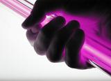 a hand grasping a pink coloured neon tube