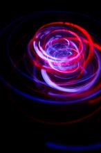 a chaotic pattern of looping blue and red lines formed from streaks of vivid light