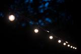 a night time view of a string of outdoor festoon party lights with white bulbs