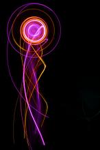 a creative vivid light painting with round focal point and trailing curved lines