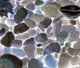 Assorted glowing rocks and pebbles backlit to give a luminous effect in a full frame background texture and pattern