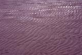 Wet sand ripples on a beach left by the receding tide in a full frame background pattern and texture