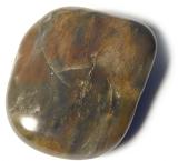 Flat water washed agate pebble or stone worn smooth by the action of the ocean tides or river over a white background