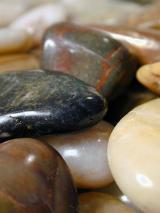 Collection of smooth pebbles or stones with their surfaces eroded to a smooth shine by the tumbling action of water in the sea or river