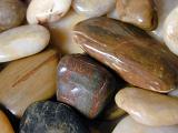 Background texture of assorted smooth colorful water worn pebbles from a beach or riverbed, full frame