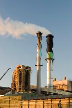 Industrial chimney at a factory or manufacturing plant emitting smoke into the air causing atmospheric pollution