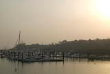 Poor air quality as the sun tries to shine through a low lying haze of smog and photochemical pollution over a coastal marina