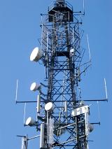 Low angle view of a steel lattice communications tower with an array of dishes for transmission and reception
