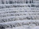 White frothy water flowing over a stepped spillway to control flow and direction of an important natural resource