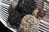 Selection of different hand crafted wicker ball decorations on a Venetian blind in front of a brick wall