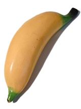 Realistic yellow wooden banana lying diagonally on a white background viewed from above