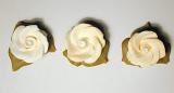 Three icing sugar roses for decorating cakes and confectionery viewed from overhead in a row on a grey background