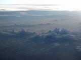 Majestic high angle view of clouds in a blue hue as seen from plane