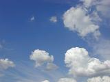 Clear sunny blue sky with fluffy white clouds an open copy space in a nature or weather concept