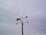 Low Angle View of Decorative Weather Vane Pointing Towards South and Shot Against Cloudy Overcast Sky