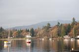Boats moored on the tranquil waters of Lake Windermere, Cumbria in a scenic autumn landscape with reflections