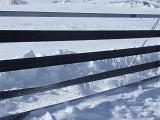 icicles forming on a mountain top snowdrift fence