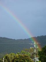 a rainbow ending over a pole mounted power transformer
