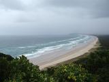 rain clouds and waves blown onto the coast  and a sandy beach