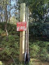 Fire warning notice asking people to take care not to start a fire mounted on a pole in Cumbria woodland