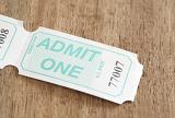 one unused admission ticket to a performance or venue with text - Admit One - and number on a wooden table