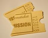 Two admission ticket stubs with personal numbers, printed on vintage yellowish paper, viewed in close-up