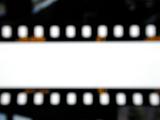 Strips of a film with edges blurred on white background, cropped close-up backdrop concept