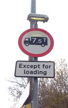 7.5 ton truck sign and loading zone limiting the size except when loading freight with street lamp above on a tall pole