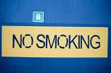 Close-up on No Smoking sign on yellow and blue background made with blue paint through a stencil