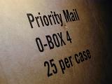 Priority Mail brown cardboard packaging box with text denoting size and quantity in an oblique angle view