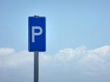 Blue Parking sign on a metal pole against a cloudy blue sky with copy space