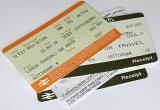 Assorted train travel tickets in a heap with the receipt and card holder copy on a white background