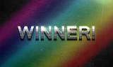 Rainbow colored sign announcing a Winner with metallic lettering and exclamation mark