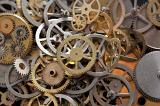 an array of metal gear cogs and components from a clockmakers parts bin