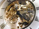 Open face vintage pocket watch showing the working mechanism surrounded by the numerals in a close up detailed view