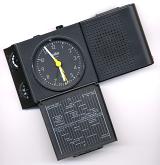 Black travel quartz alarm clock with loudspeaker, buttons and world time zone map, close-up with copy space on gray