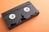 Old plastic casing of a VHS video tape lying on an orange background with copy space viewed high angle