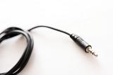 A black coloured audio lead with 3.5mm TRS jack plug on the end