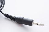 Audio jack 3.5 mm stereo plug with black cord in plastic body close-up on white background with copy space