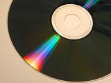 Iridescent bright colorful spectral shine on a CD or DVD disc in a close up view refracted into the colors of the rainbow