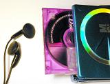 Personal music concept with an audio disc in a colorful pink case and ear buds or earpieces over a white background