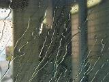 Water rivulets on a car window in a car wash running down the glass in a full frame background