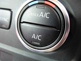 Circular air conditioning control knob on the black vinyl dashboard in a car in a close up view