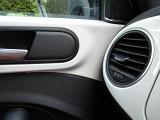 Close up detail of circular adjustable vent inside automobile with neutral color scheme