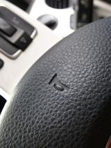 Close up on horn symbol in steering wheel for automobile with bumpy textured surface
