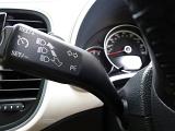 Close up on a car indicator stalk on the steering column showing the controls for the headlights and indicators